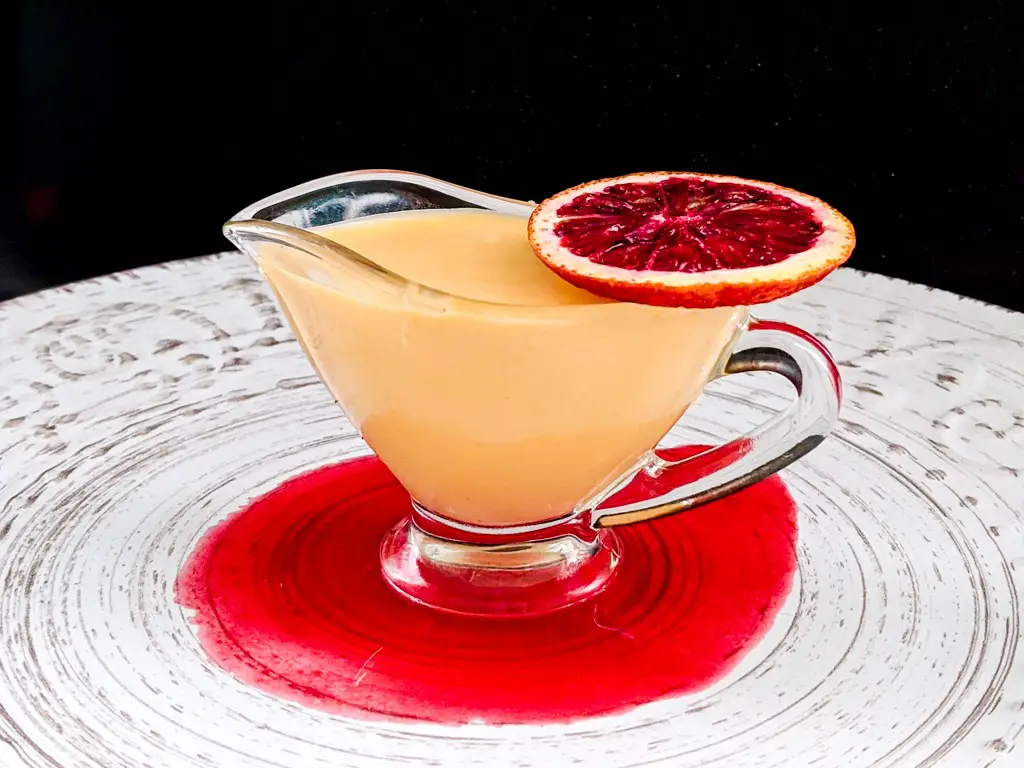 blood orange Crème Anglaise in a pouring vessel