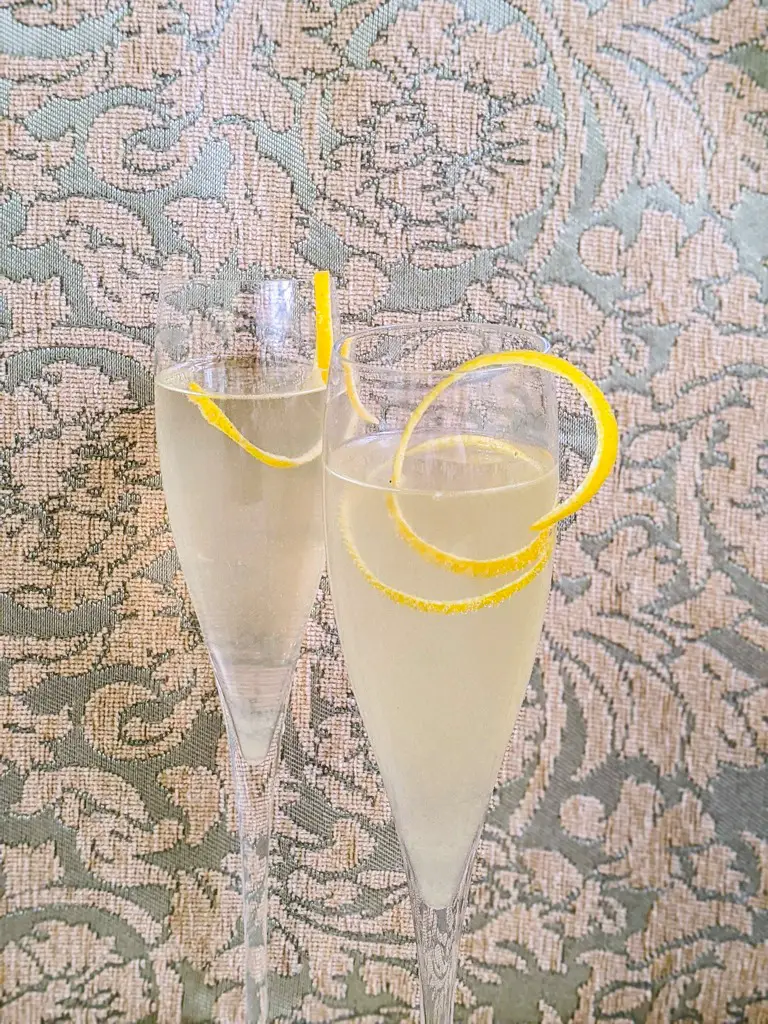 Lemon peel garnish for the french 75 cocktail in a fluted champagne glass