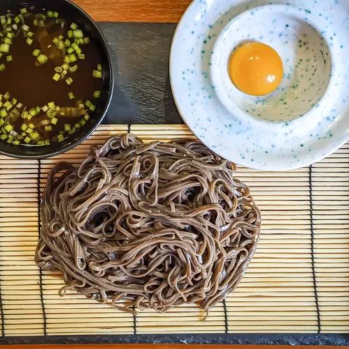 Zaru Soba on a bamboo mat with dipping sauce and egg yolk