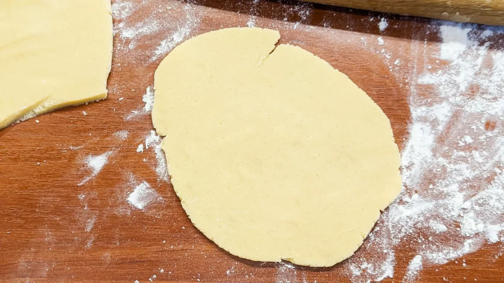 a sheet of sweet pate sucree dough on a wood floured surface