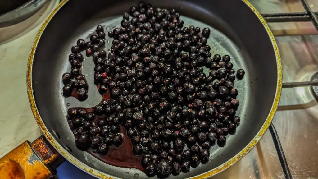 cooking blackcurrants and lemon juice in a pan