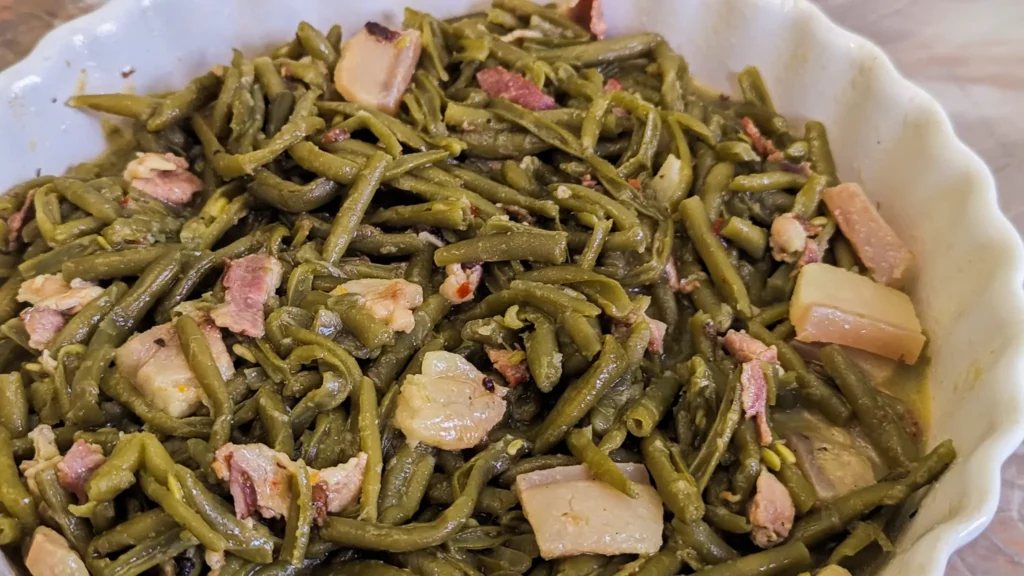 Southern Style Green Beans with pork and bacon in a chafing dish on a marble counter