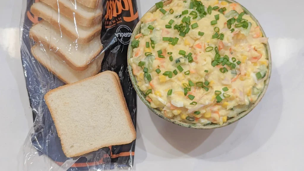 a loaf of bread and a bowl of japanese potato salad to make a potato salad sando