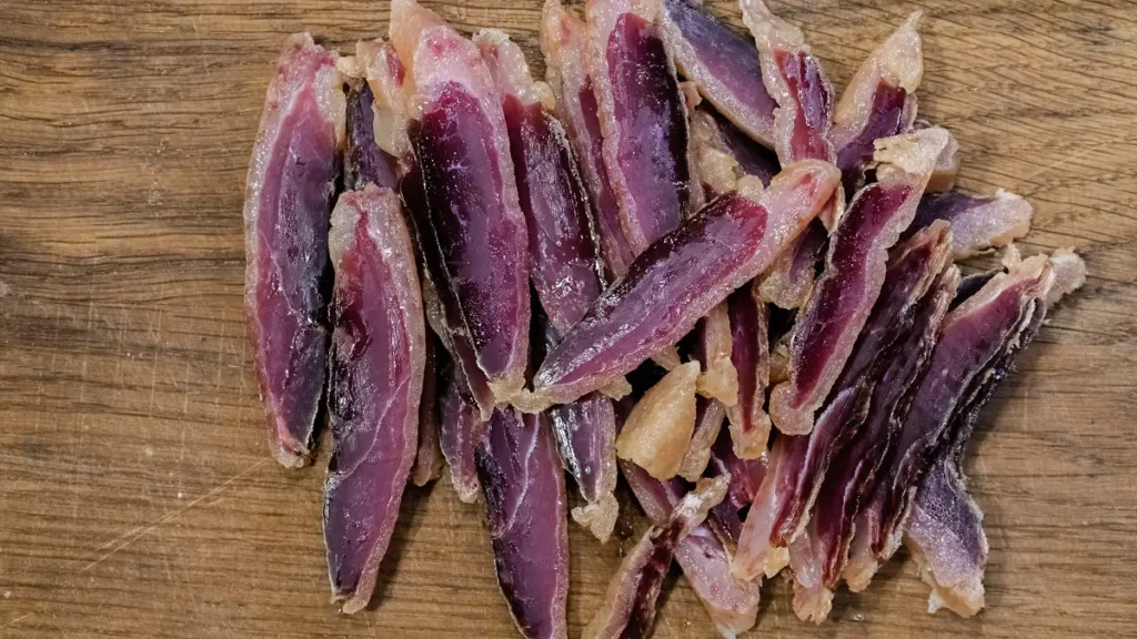 thin slices of homemade duck prosciutto on a cutting board