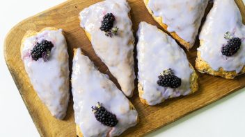 lavender blackberry scones on a cutting board with garnishes, top down view
